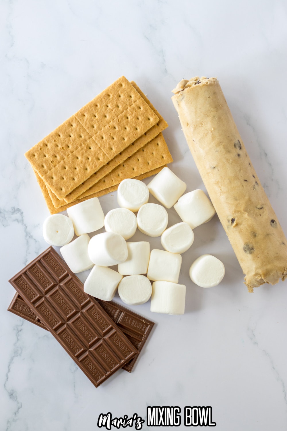 graham crackers sheets, cookie dough, chocolate bars and marshmallows on a marble counter