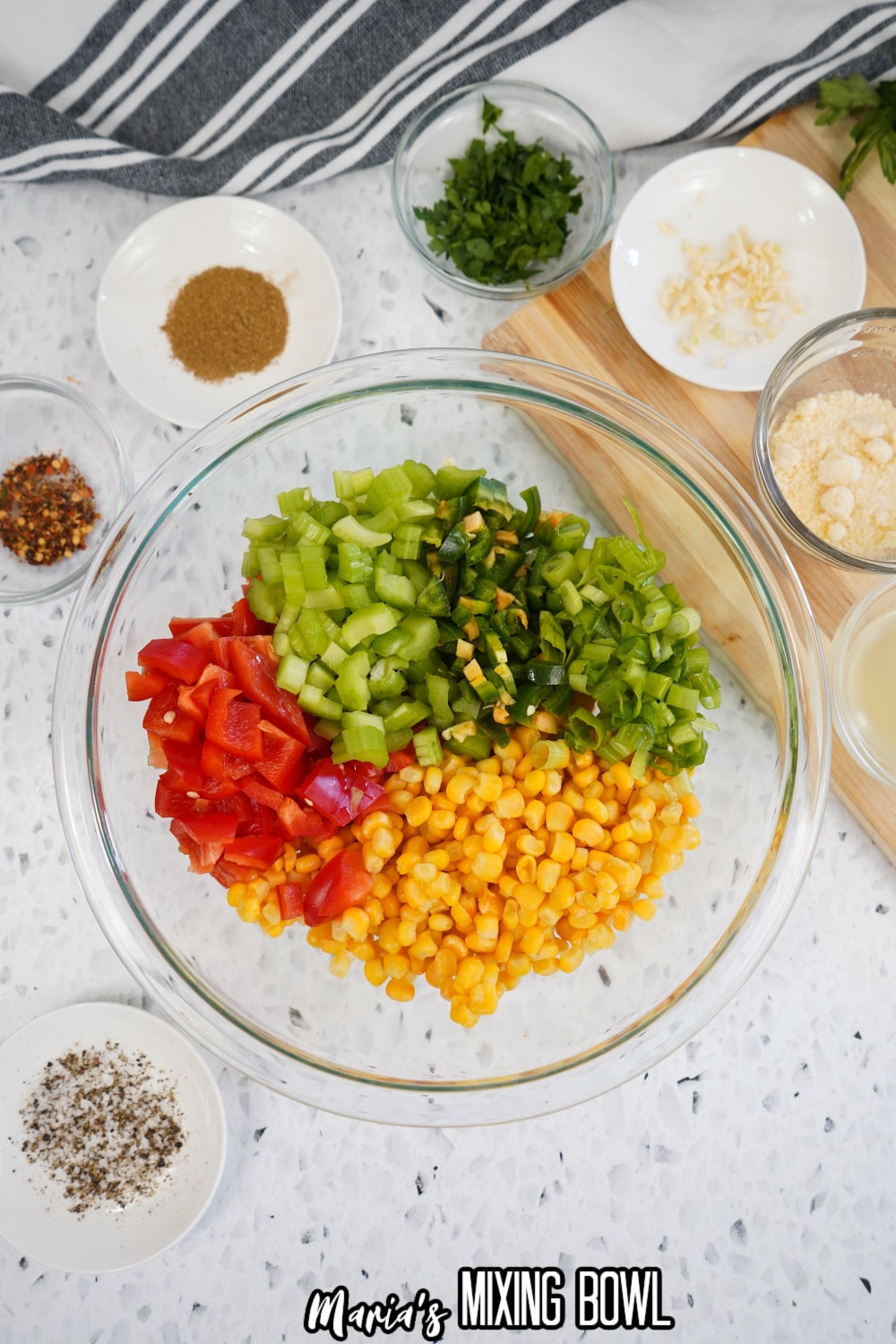 tomatoes, celery, jalapeno, green onions and corn in a glass mixing bowl