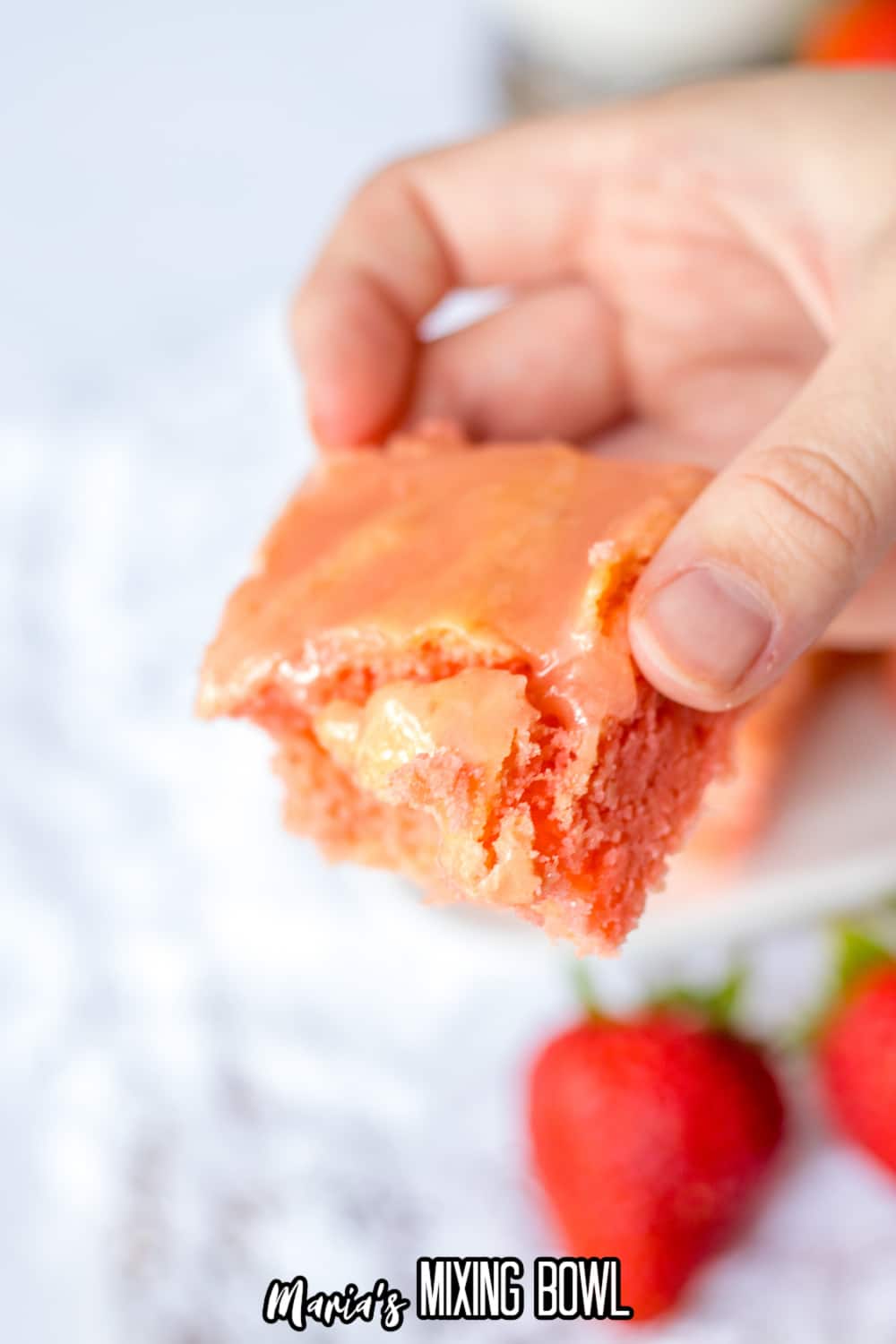 slice of strawberry cake mix brownie held in womans hand