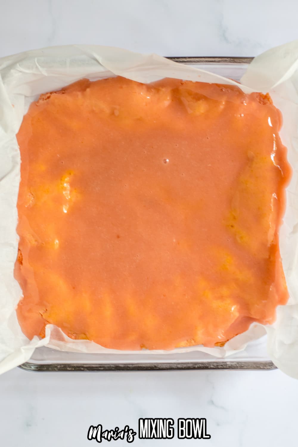 strawberry glaze being poured on strawberry brownies