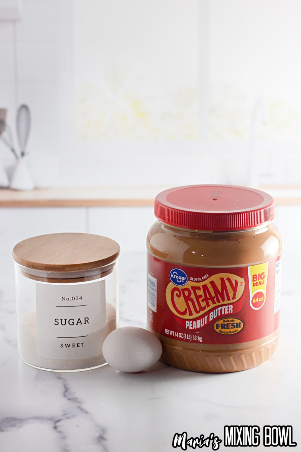 jars of peanut butter and sugar and an egg on a marble background