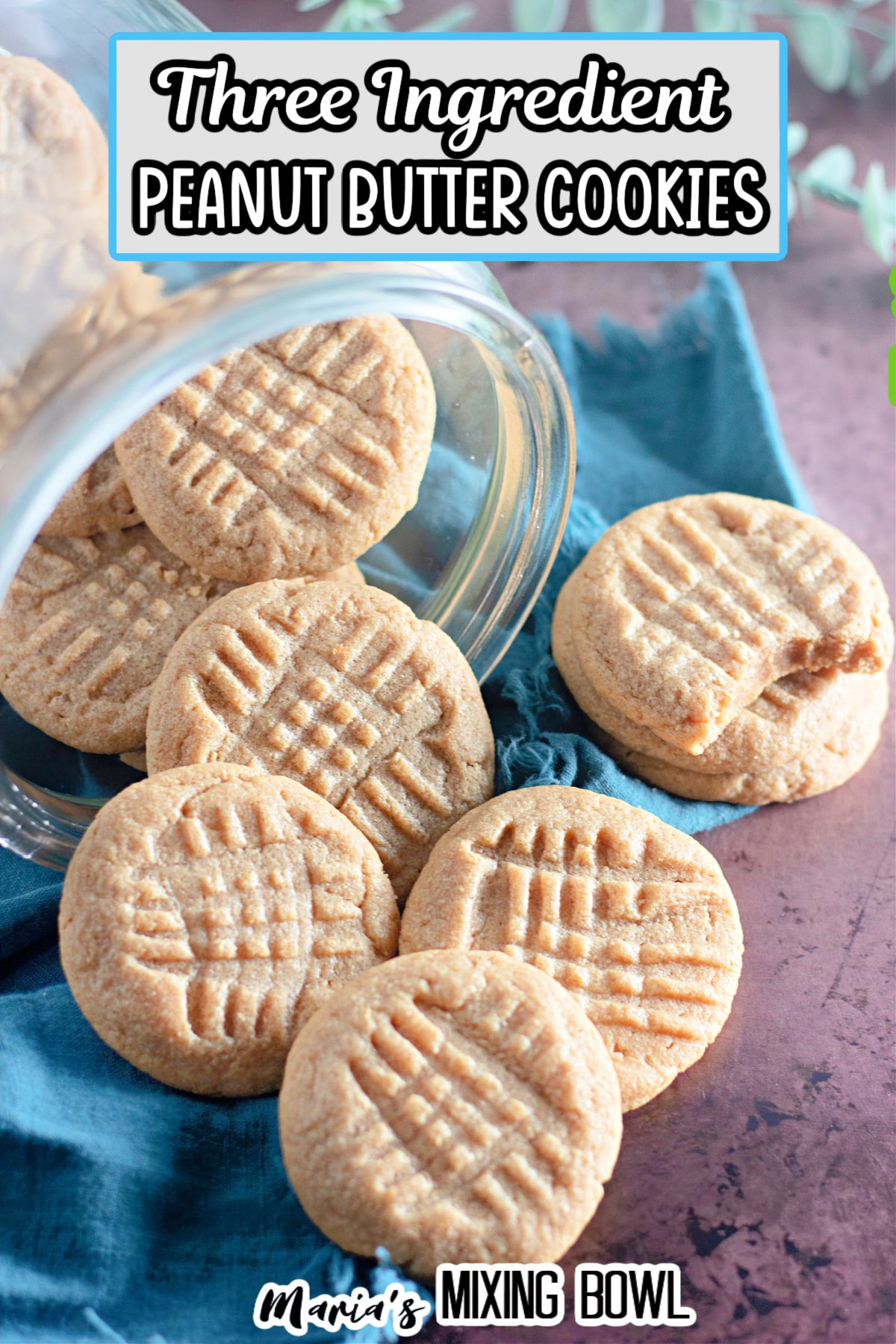peanut butter cookies being spilled out of a glass jar on a wooden board