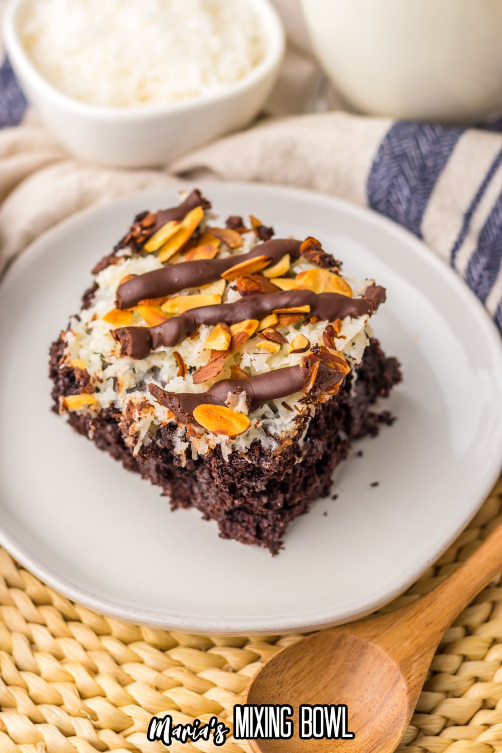 slice of almond joy poke cake on a white plate