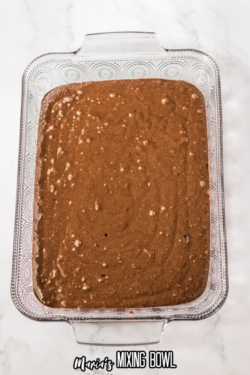 chocolate cake batter in a glass casserole dish ready for the oven