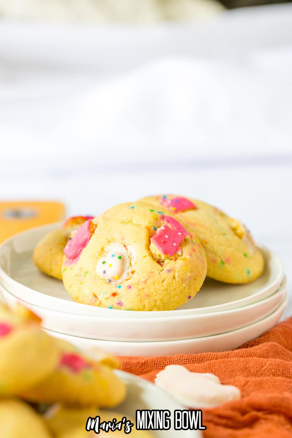 three cookies on top of three small plates stacked on top of each other.