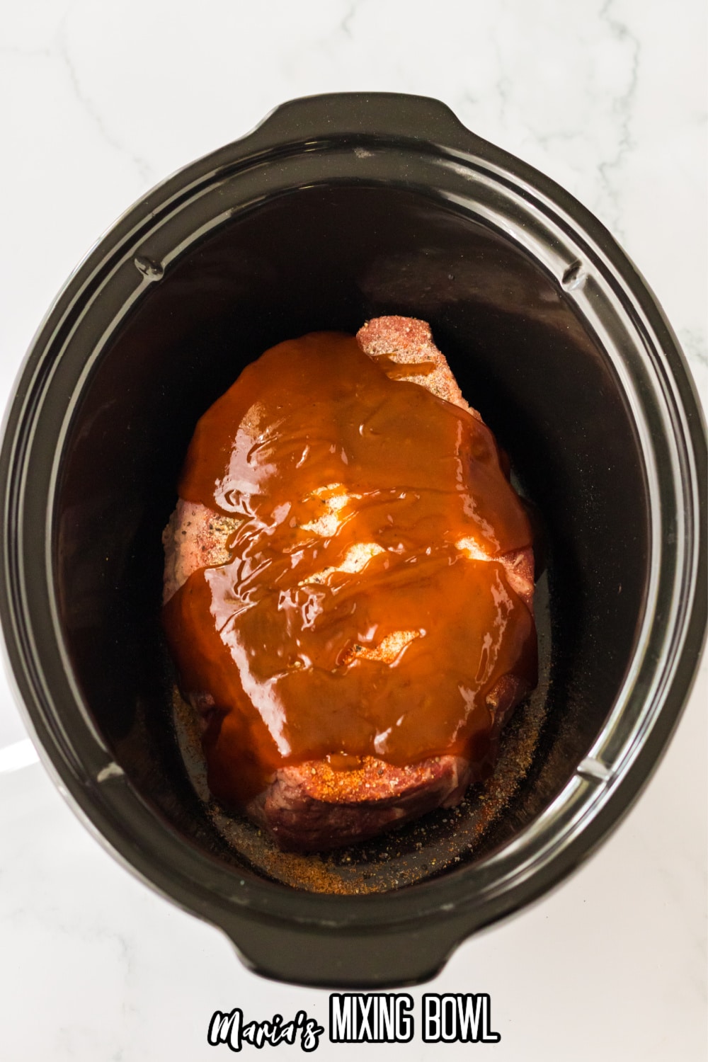 beef chuck roast, seasonings, and bbq sauce in a slow cooker