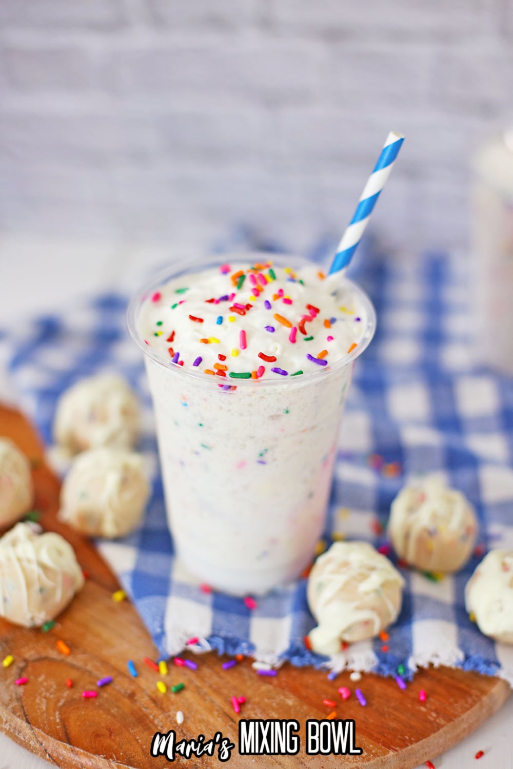 birthday cake Frappuccino on a blue and white checkered towel with a blue and white striped straw
