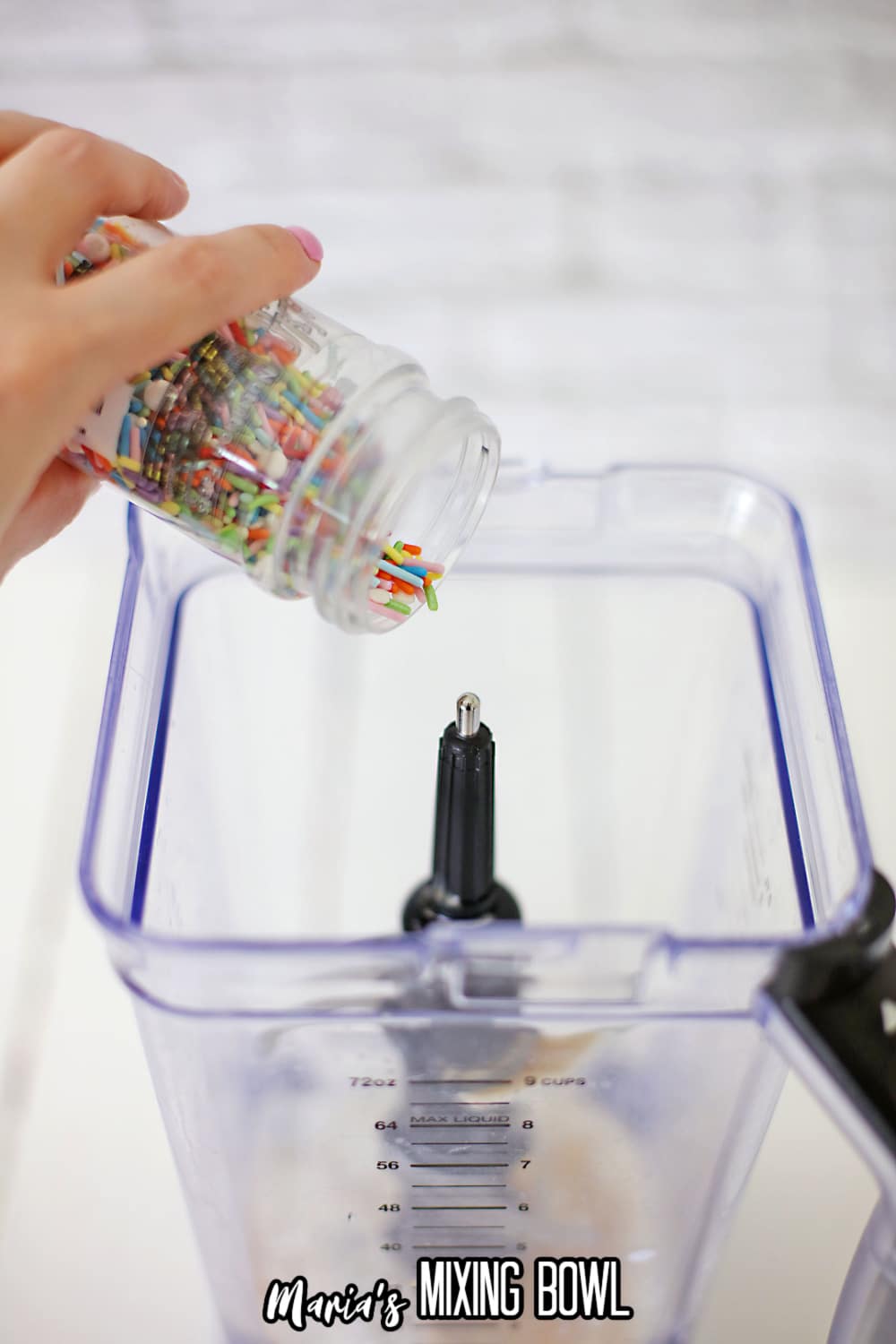 rainbow sprinkles being added to a blender with ice cream