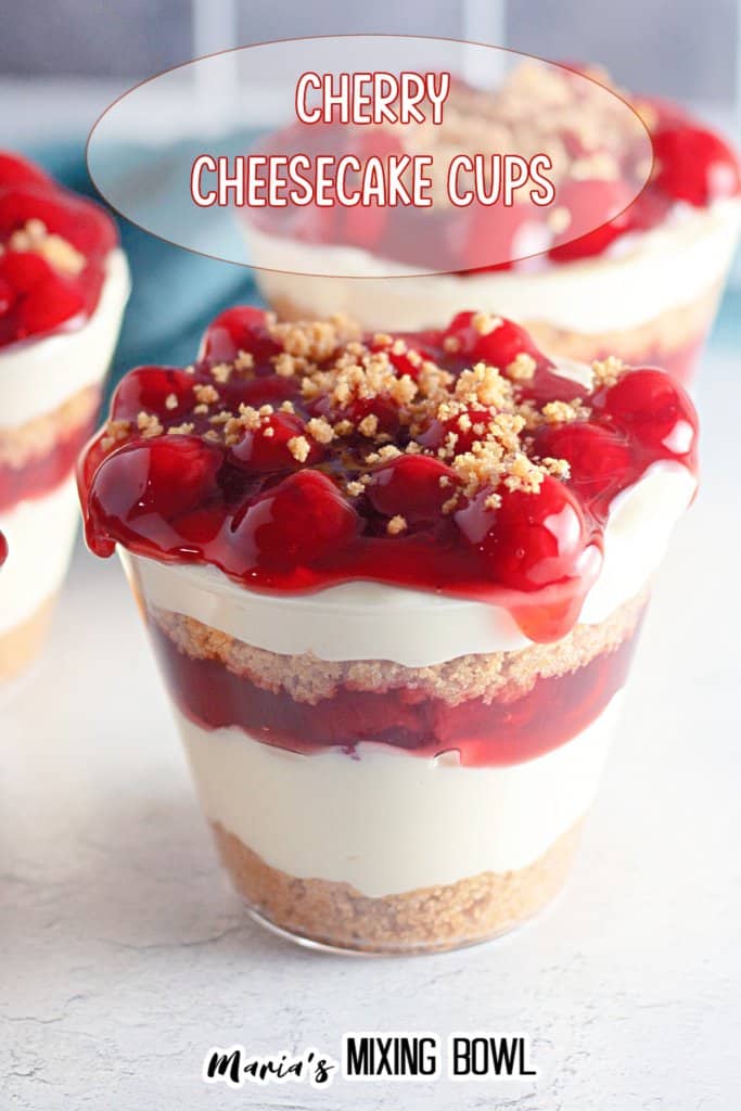 close up of a cherry cheesecake cup on a white marble background