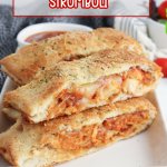 slices of stromboli on a white rectangular platter with a jar of pasta sauce