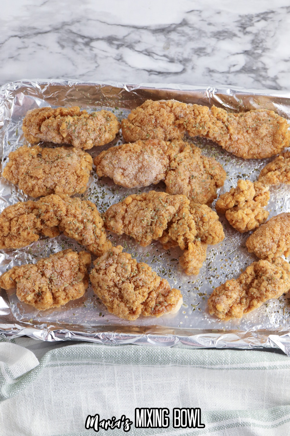 frozen chicken fingers on a aluminum foil baking sheet