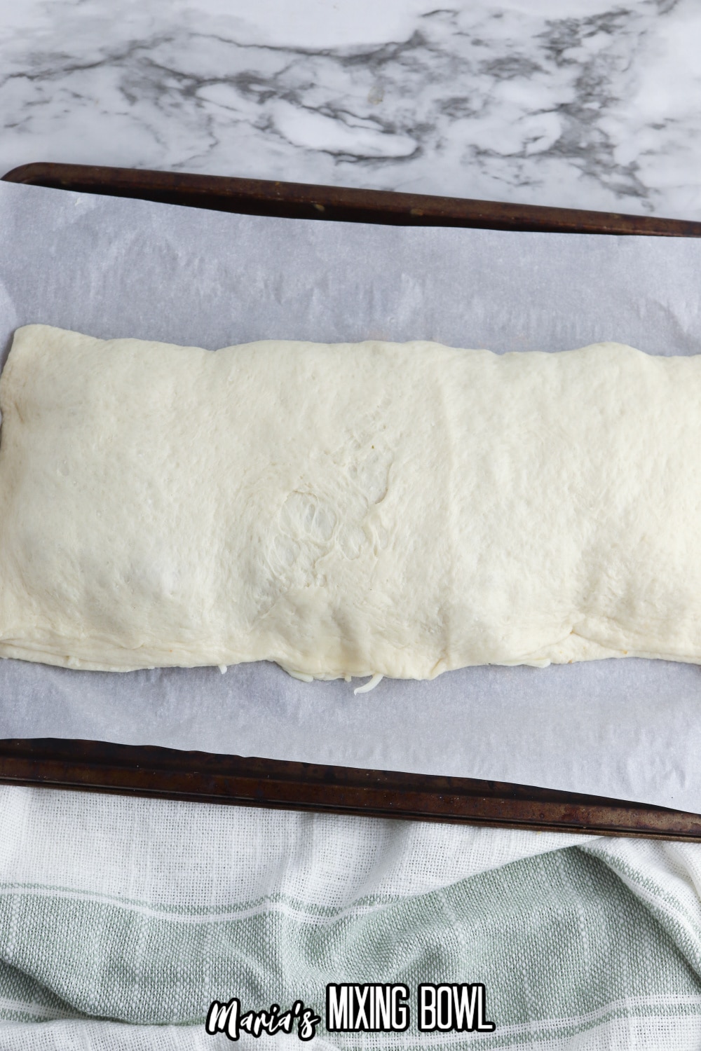 raw stromboli sealed on a parchment lined baking sheet