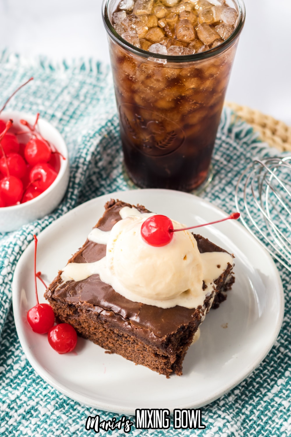 slice of double fudge coca cola cake on a small white plate topped with a scoop of ice cream