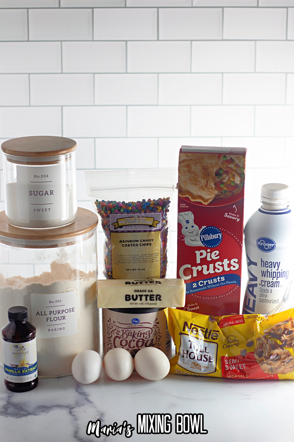 bowls of sugar, flour, vanilla, butter, cocoa powder, eggs, chocolate chips, pie crusts and heavy whipped cream