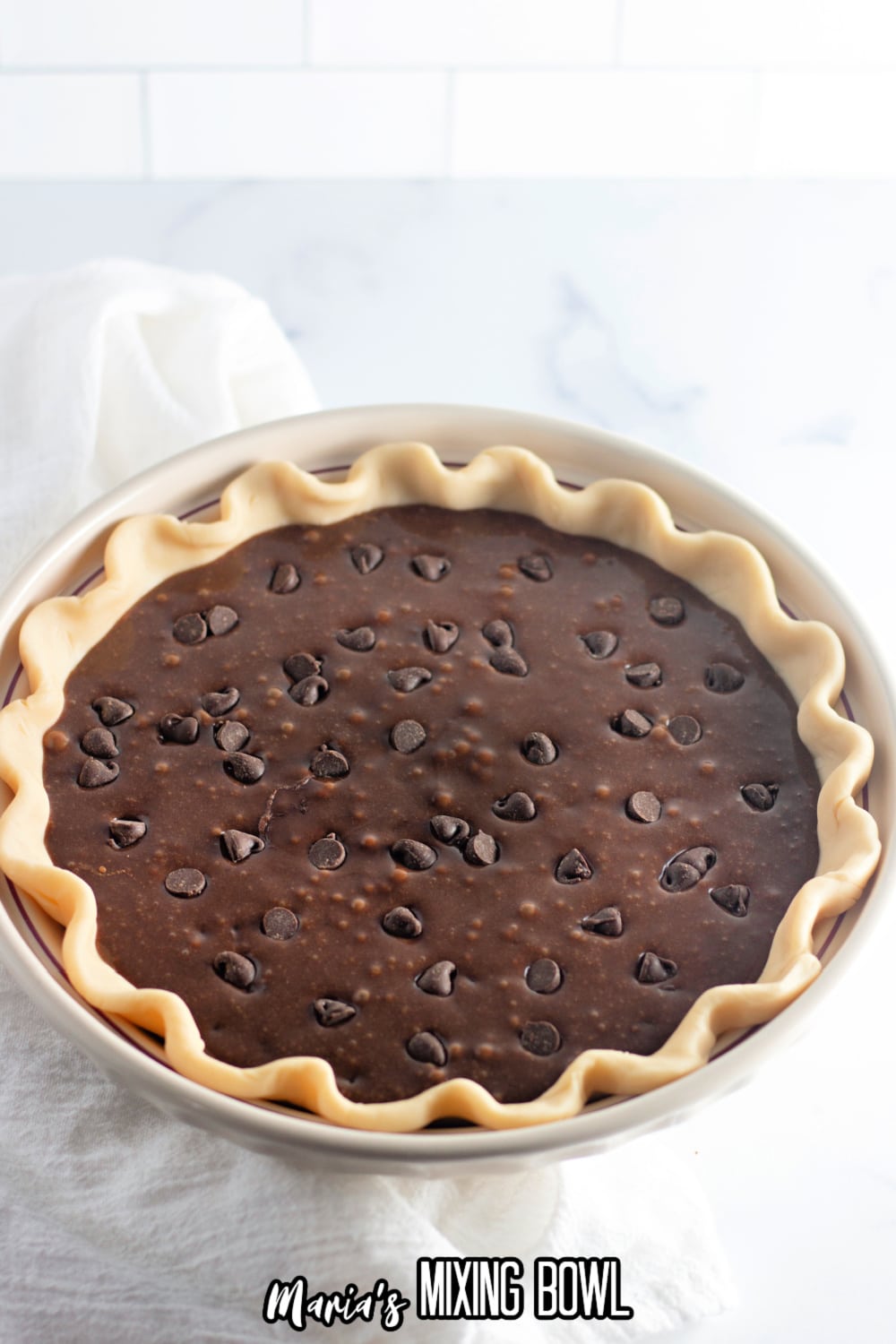 brownie batter in a pie crust in a white pie plate