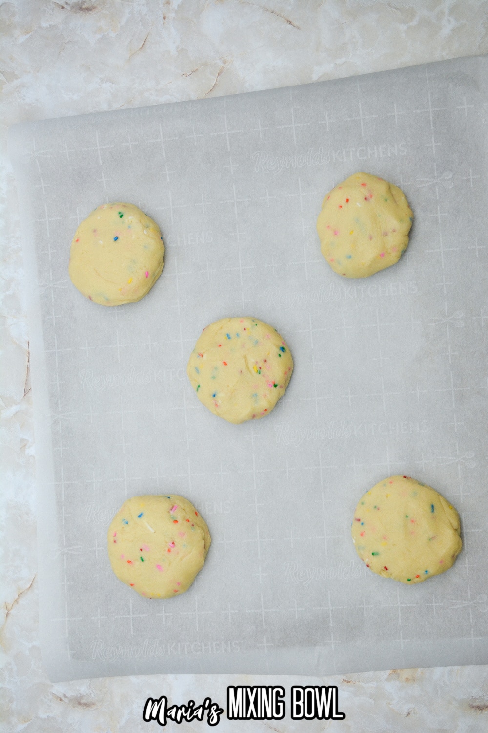 raw cookie dough on a parchment lined baking sheet