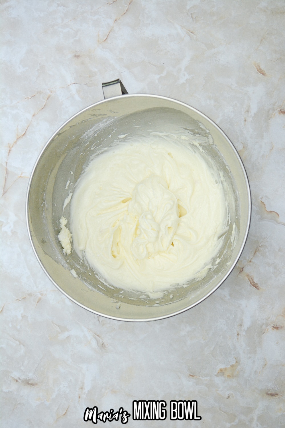 cream cheese frosting in a stainless steel mixing bowl