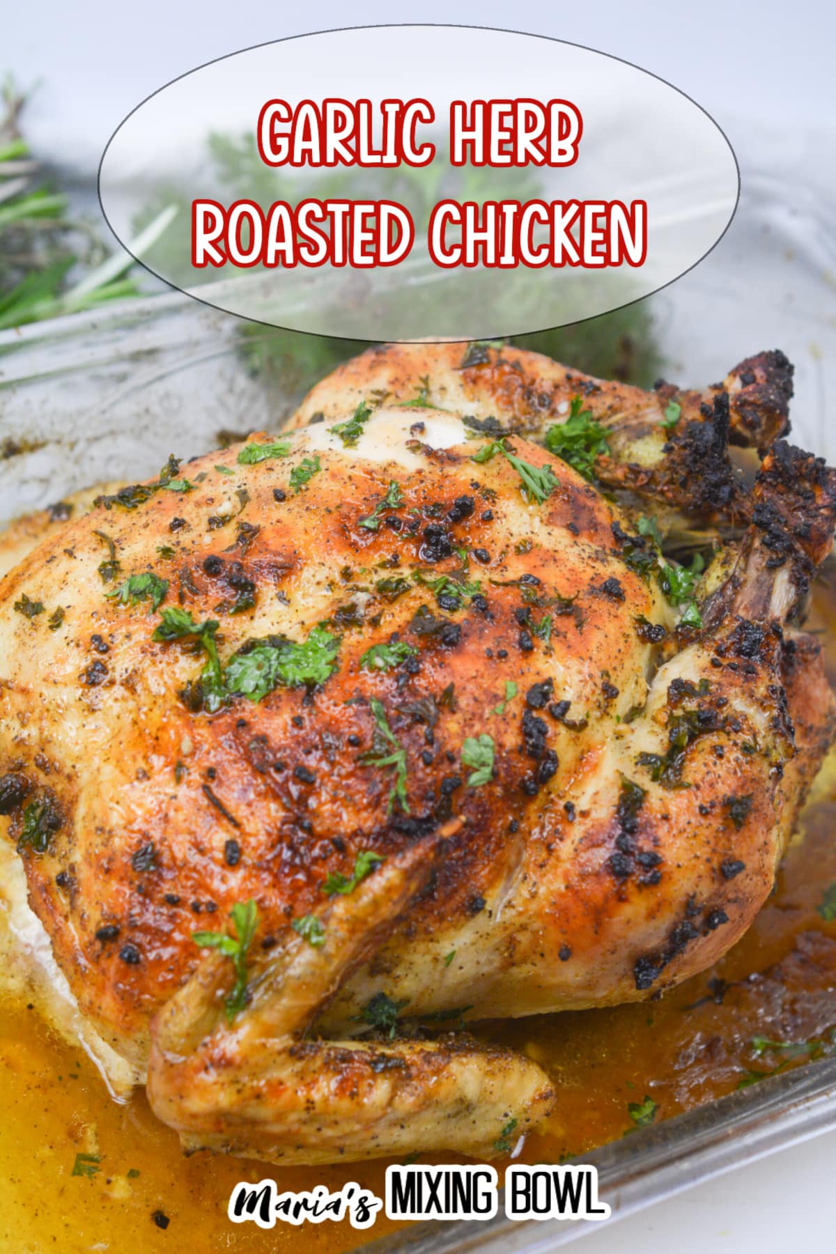 whole roasted chicken topped with fresh parsley in a glass baking dish