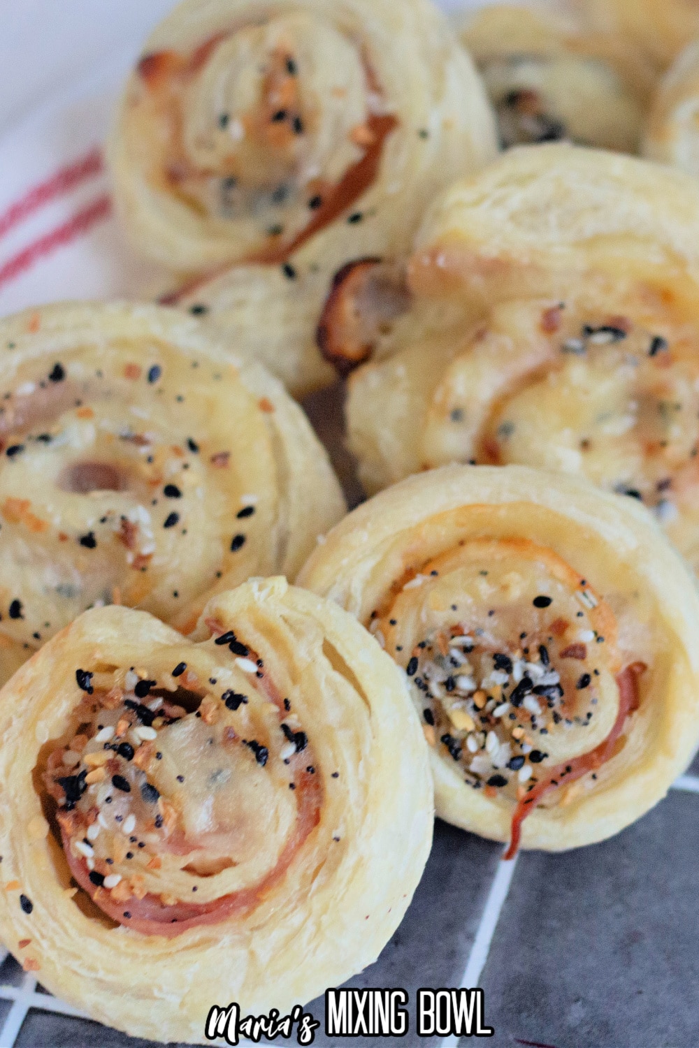 slices of ham and cheese pinwheels on a cooling spray on a dark background