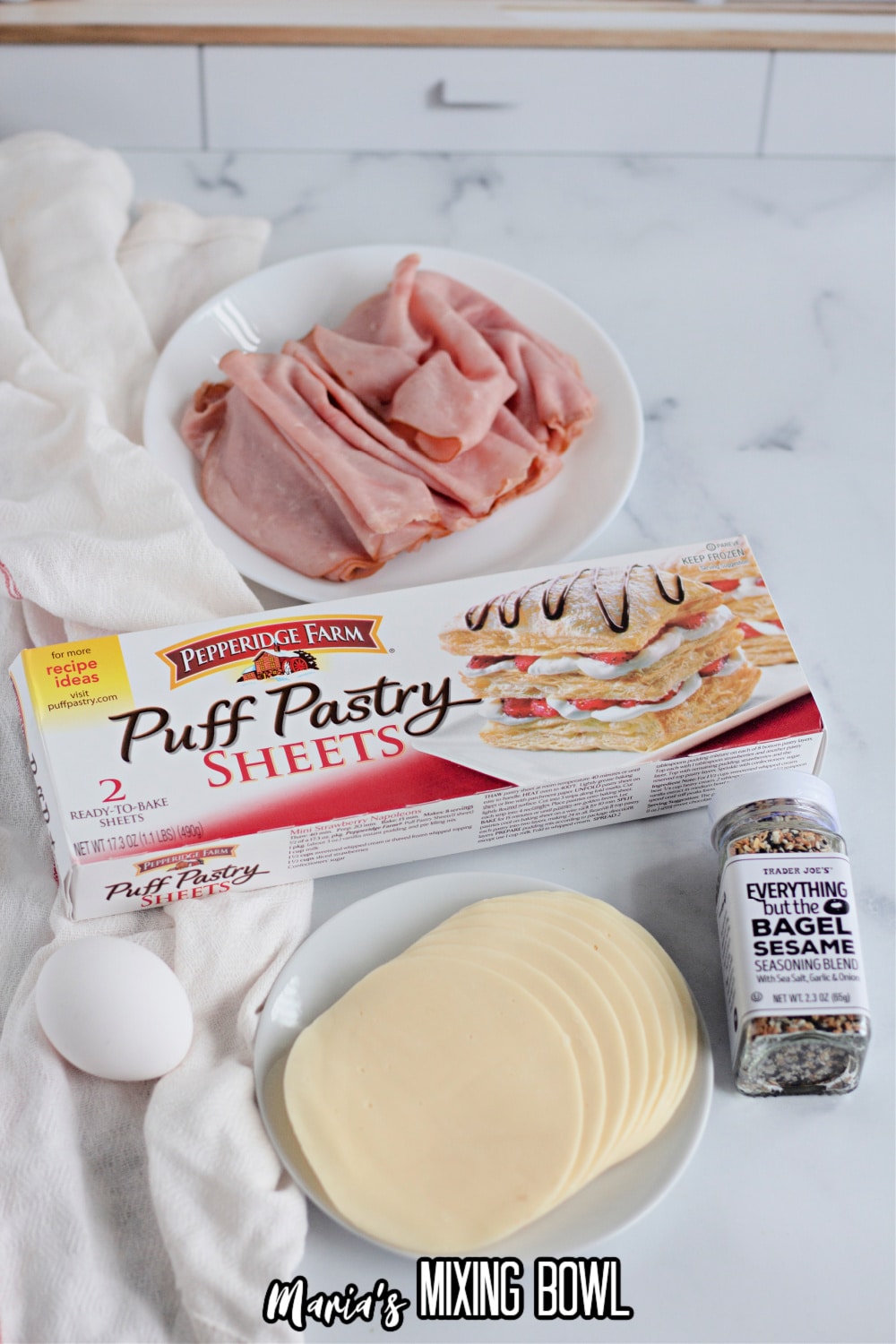 slices of ham, puff pastry, egg, slices of provolone cheese, and everything bagel seasoning
