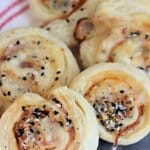 slices of ham and cheese pinwheels on a cooling spray on a dark background