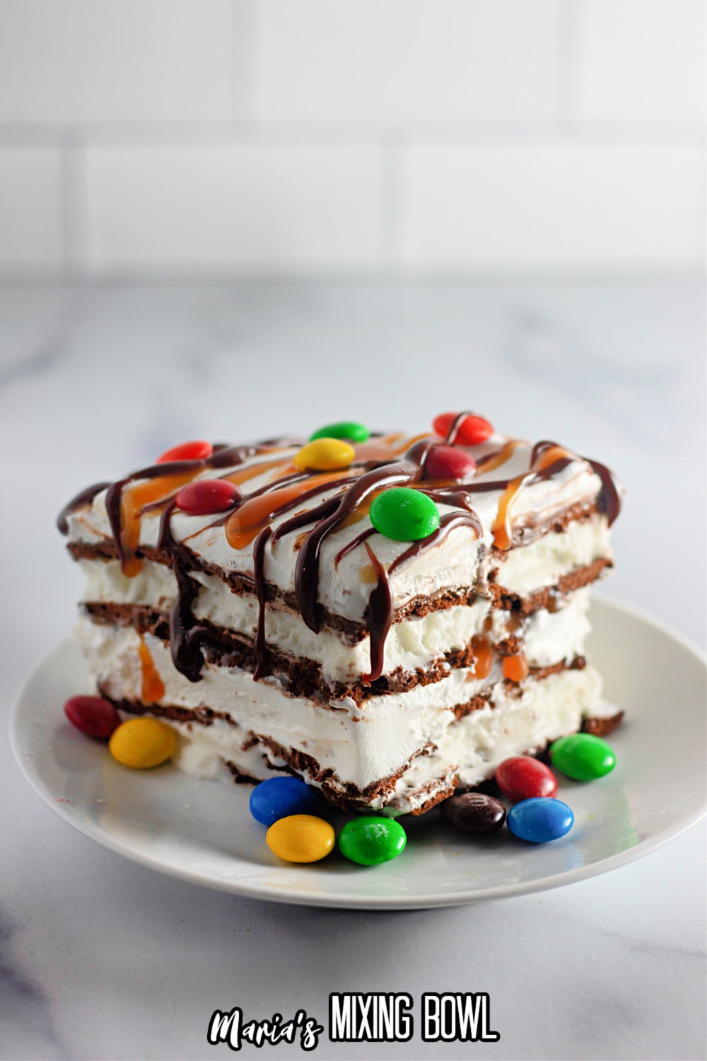 slice of ice cream sandwich cake topped with m&m's on a white plate