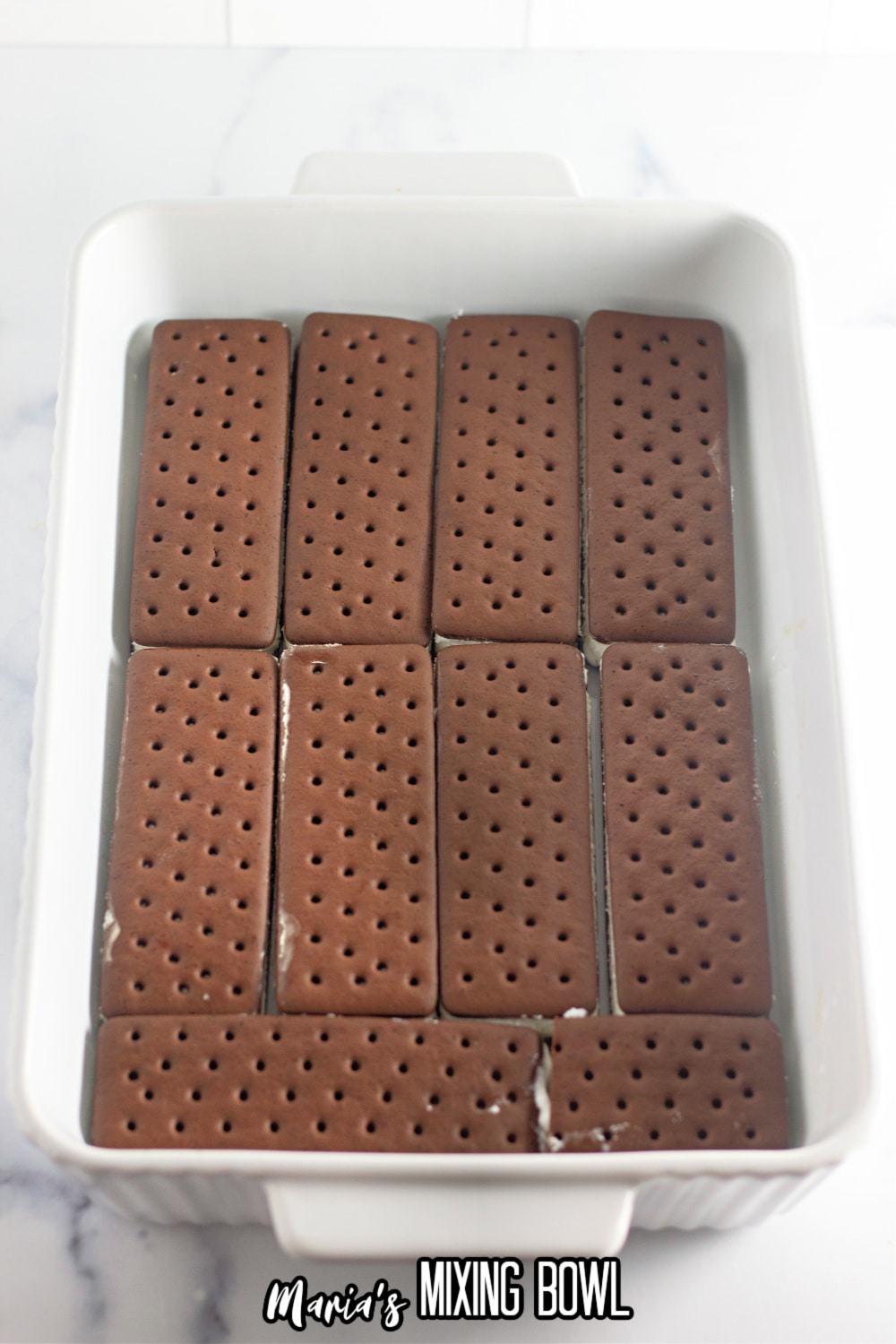 ice cream sandwiches laid on the bottom of a white casserole dish