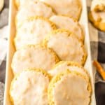 12 iced oatmeal cookies lined in two rows on a white rectangular platter.