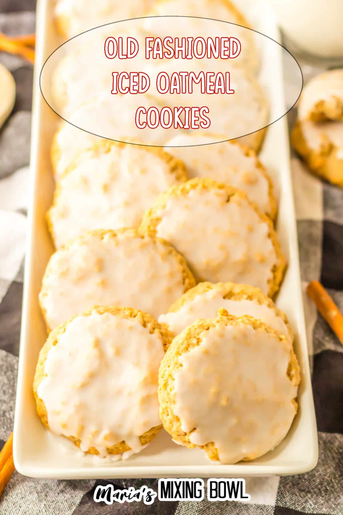 12 iced oatmeal cookies lined in two rows on a white rectangular platter.