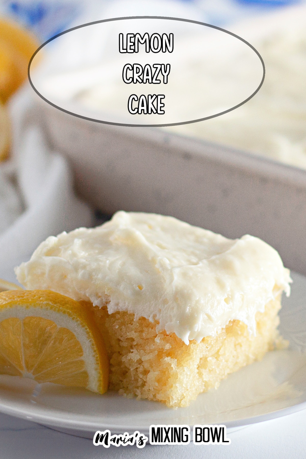 slice of lemon crazy cake frosting with cream cheese frosting on a white plate with lemon wedges