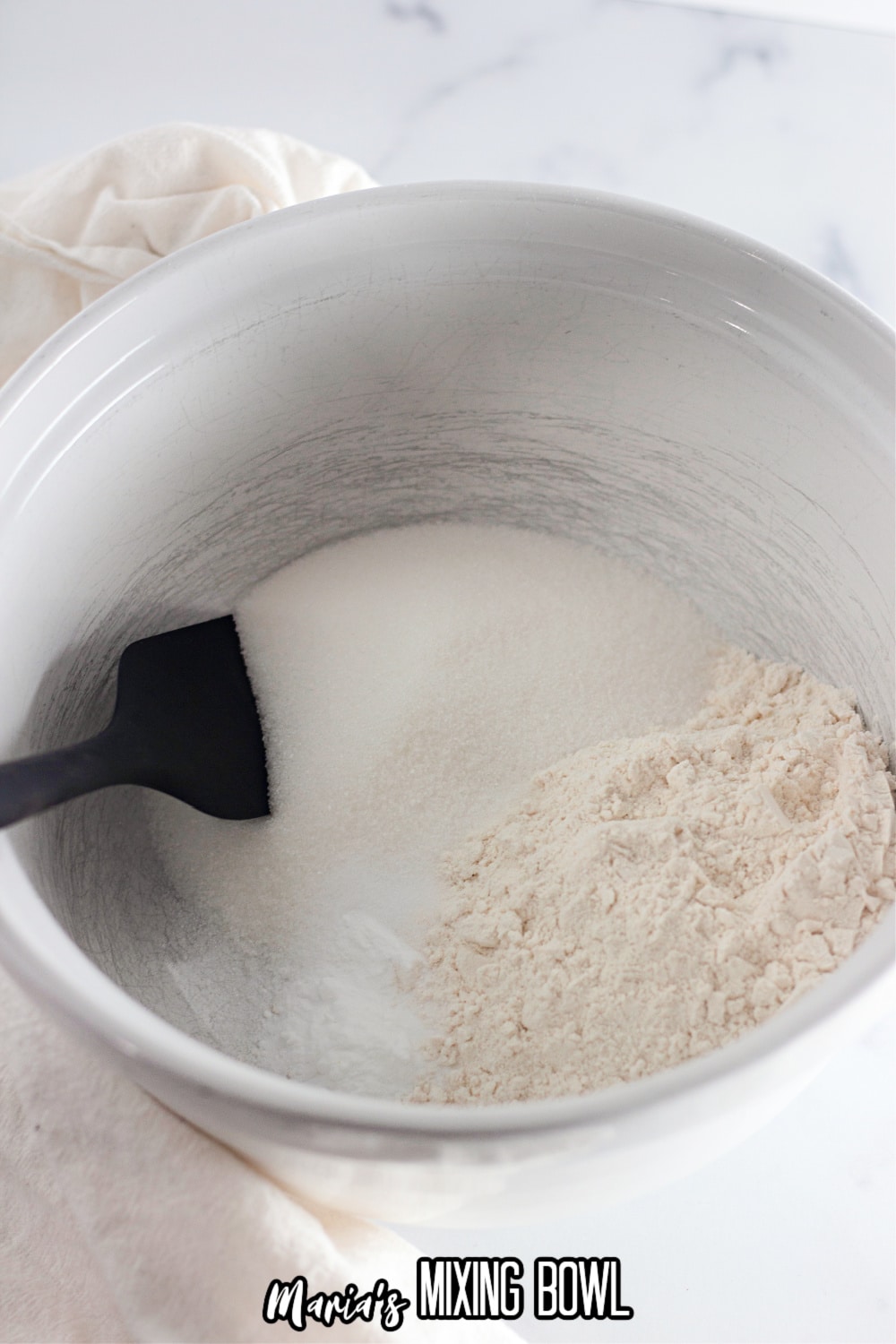 baking soda, sugar, all purpose flour and salt in a white mixing bowl with a black mixing spoon