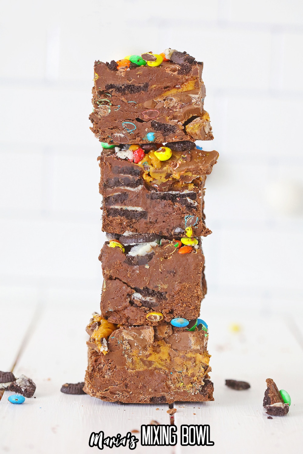 four pieces of loaded peanut butter cup fudge stacked on top of each other
