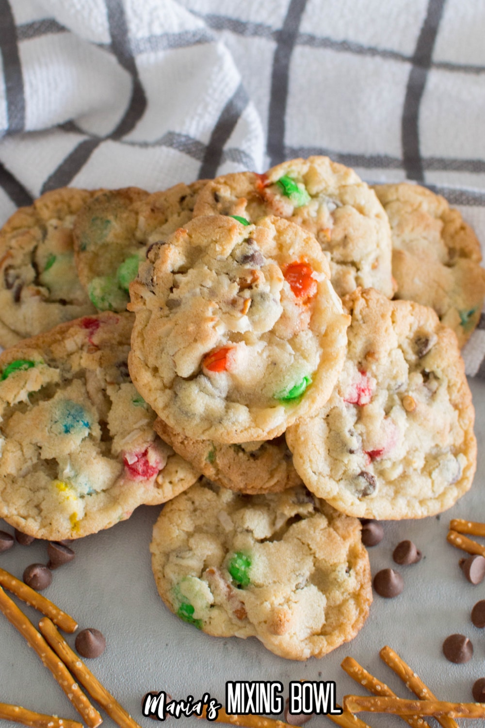 loaded pretzel cookies on a marble counter with pretzels and chocolate chips around it