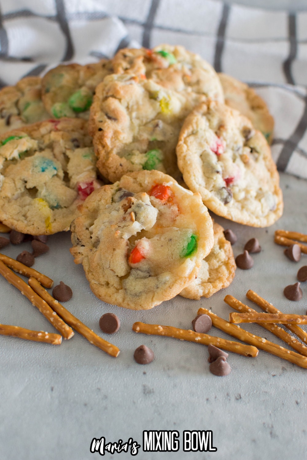 loaded pretzel cookies on a marble counter with pretzels and chocolate chips around it