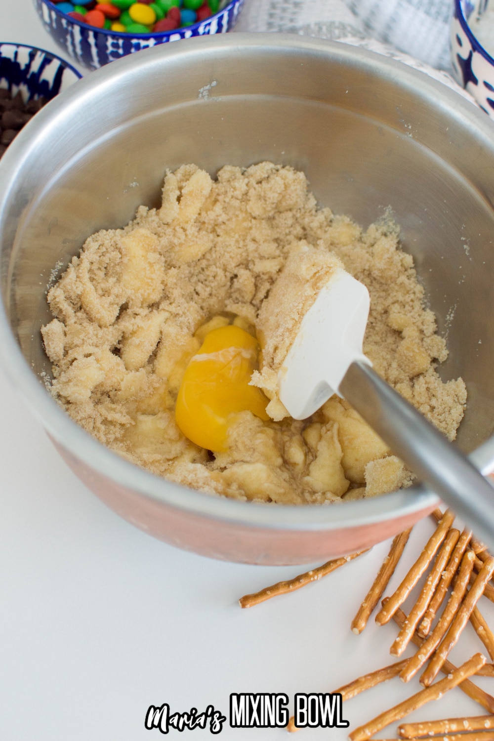 butter, eggs, and sugar being mixed in a stainless steel mixing bowl