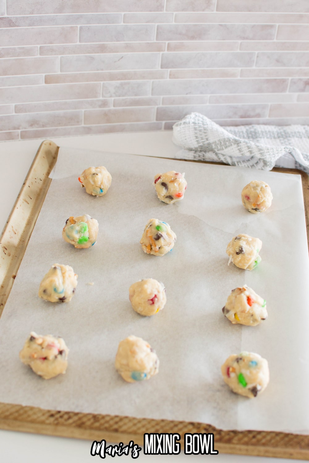 cookie dough balls on a parchment lined baking sheets