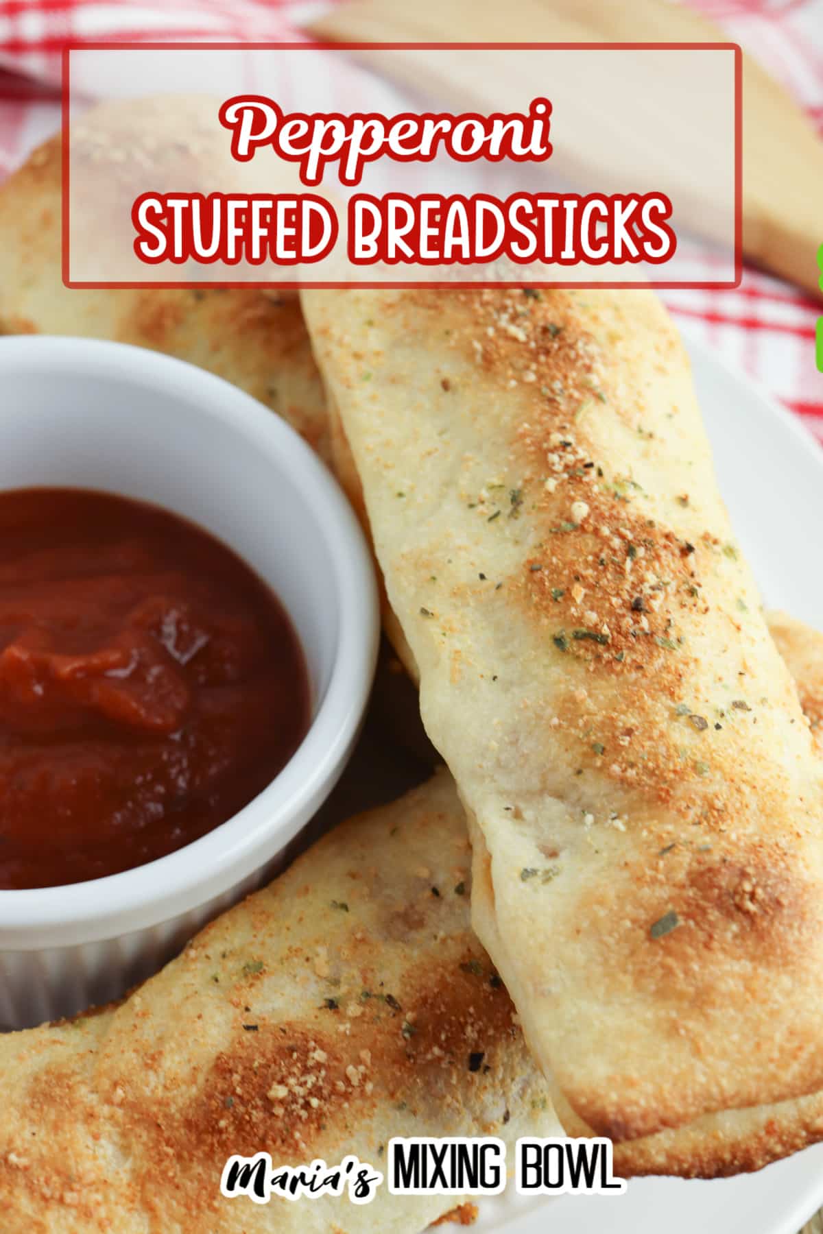 three stuffed breadsticks on a white plate with a bowl of pizza sauce