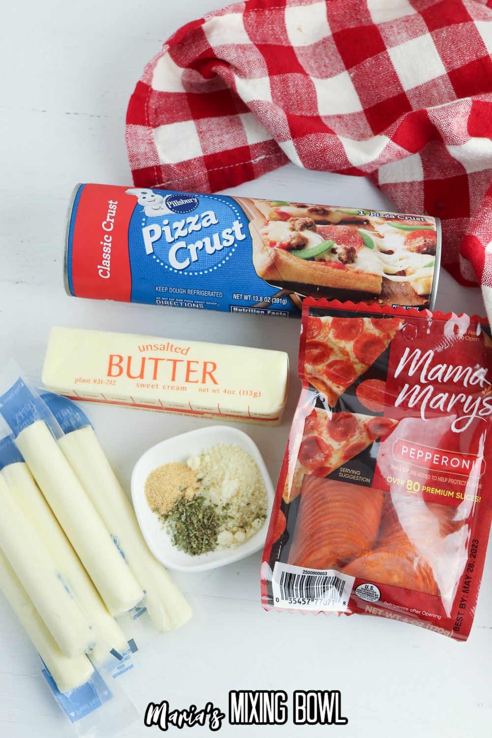 pizza crust, butter, cheese sticks, seasonings, and pepperoni on a white background