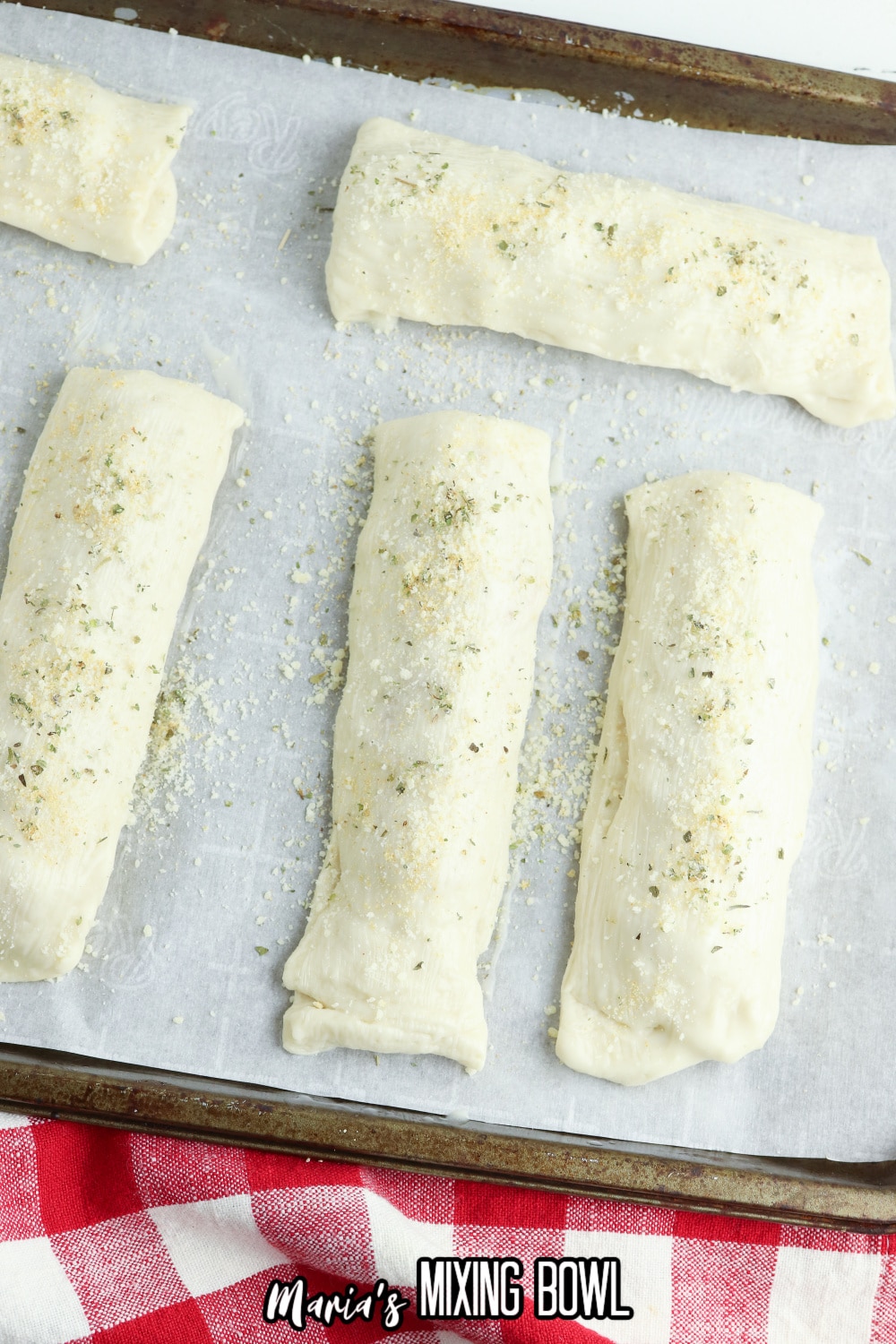 seasoned breadsticks on a parchment lined baking sheet