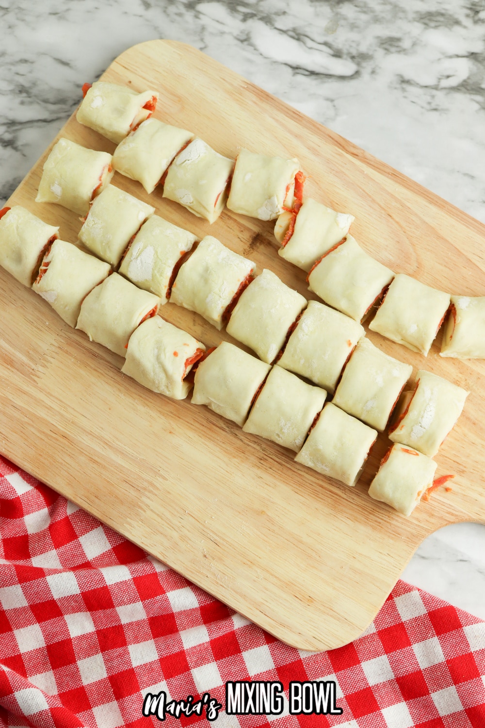 pizza bites being cut into slices on a wooden cutting board