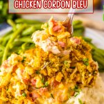 fork full of chicken cordon bleu on a plate with mashed potatoes and green beans