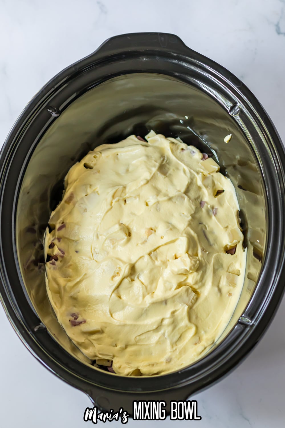 raw chicken breasts topped with cream of chicken soup in a slow cooker