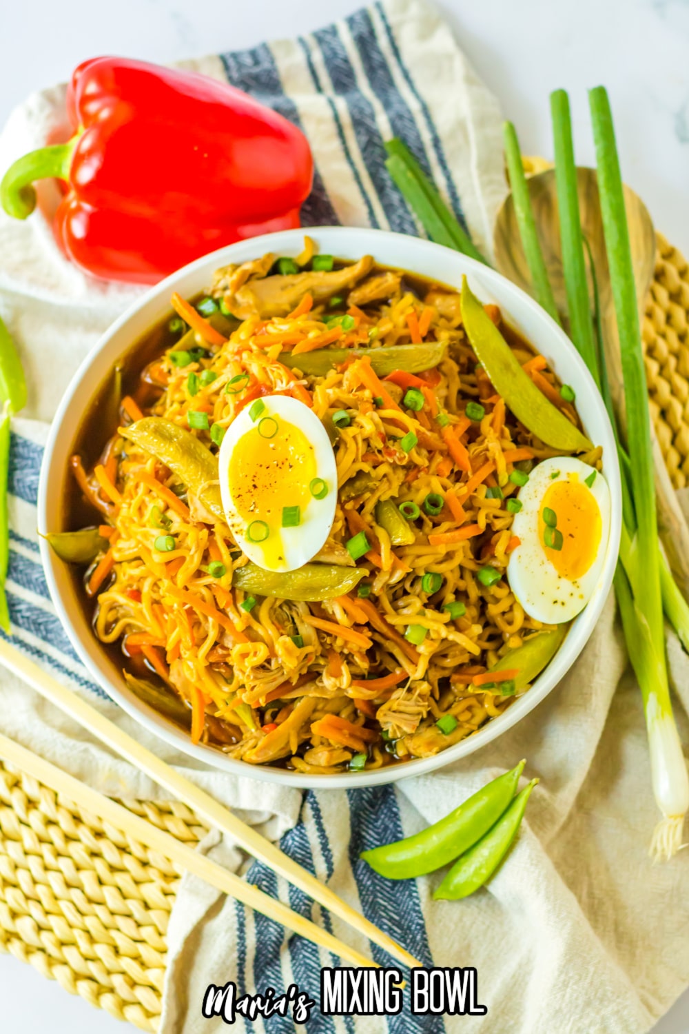 birds eye image of a bowl of chicken ramen stopped with hard boiled egg.