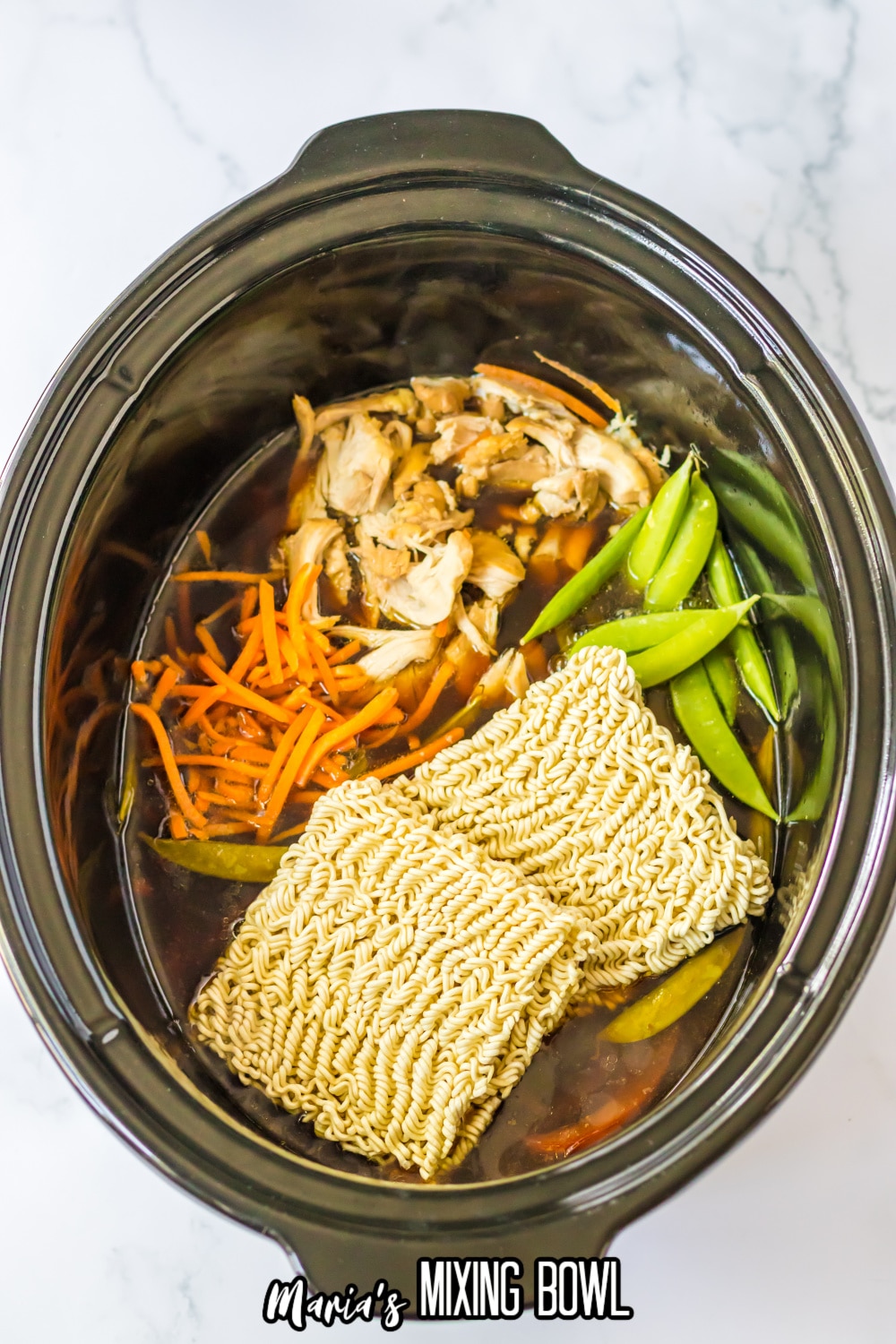 uncooked ramen in the slow cooker with chicken, vegetables and broth
