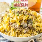 white bowl filled with slow cooker pot roast stroganoff with a glass of iced tea in the background