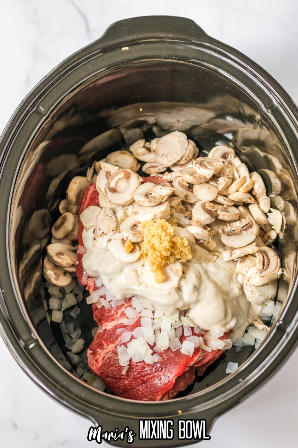 chuck roast, mushrooms, onions, cream of mushroom soup, and minced garlic in a slow cooker