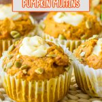 four pumpkin muffins filled with cream cheese filling in the center on a table.