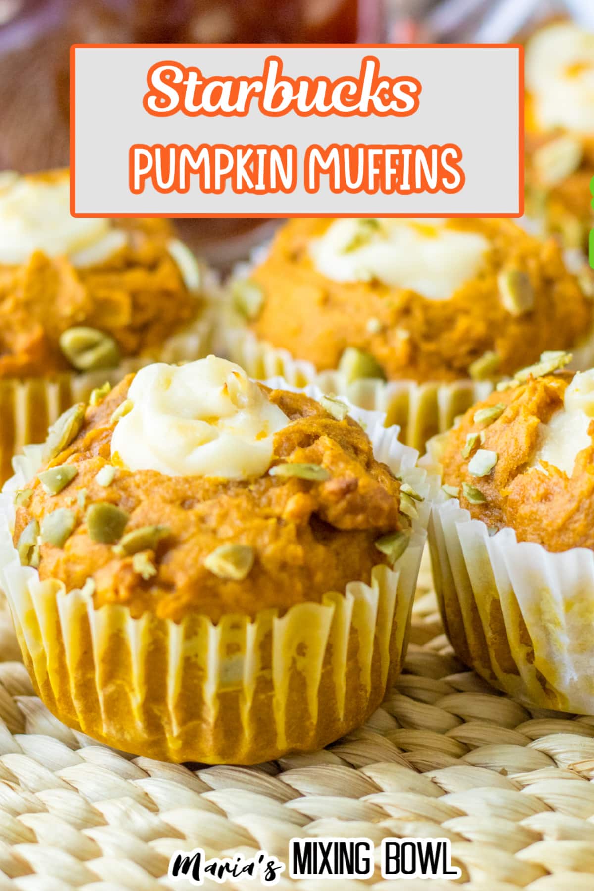 four pumpkin muffins filled with cream cheese filling in the center on a table.