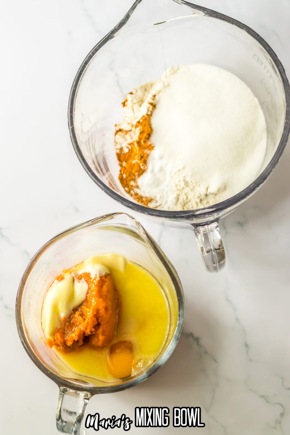 large measuring cup filled with flour, sugar, pumpkin pie spice, baking soda, baking powder, and small measuring cup filled with egg, butter, and pumpkin puree.