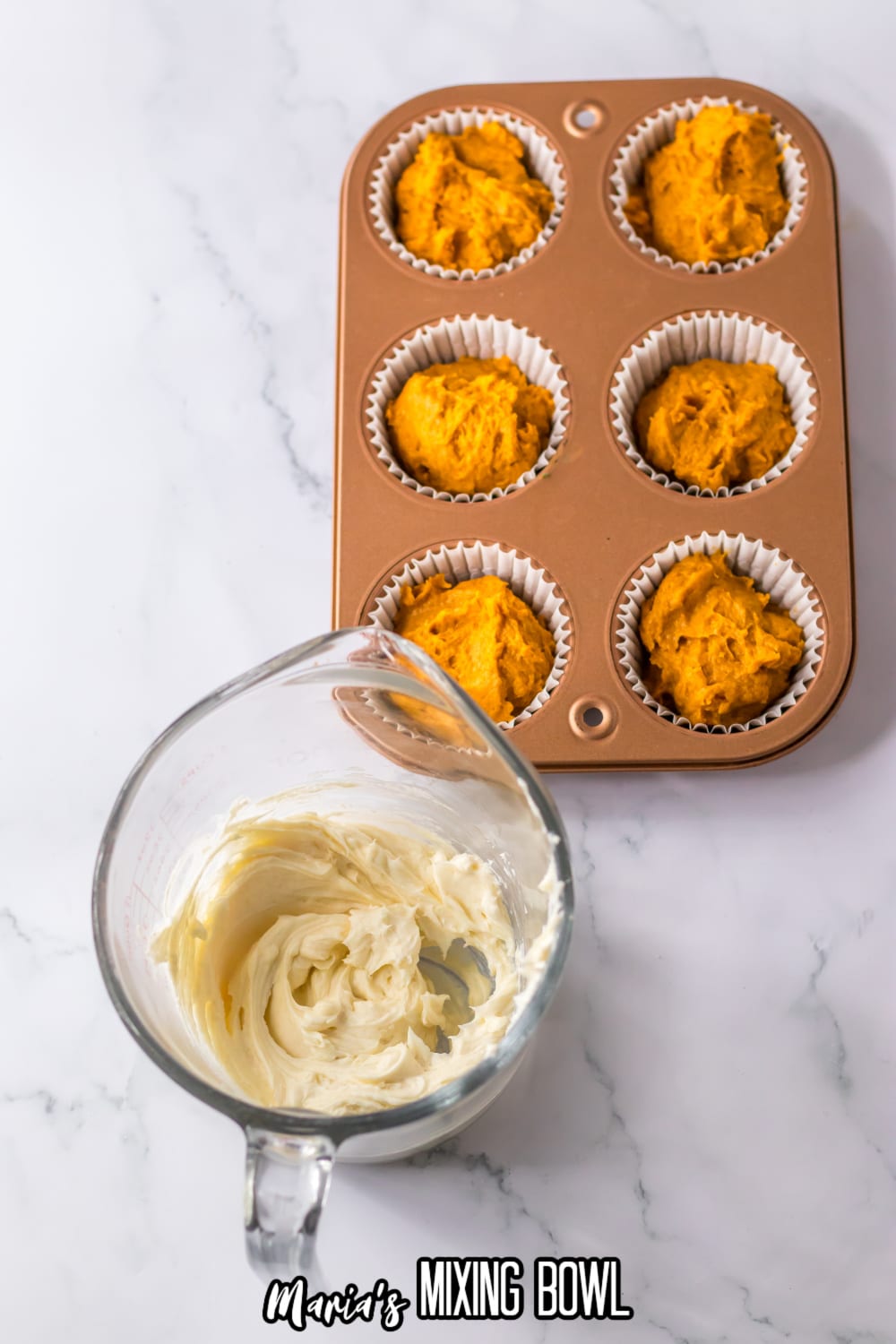 cream cheese and powdered sugar being mixed in a glass measuring cup